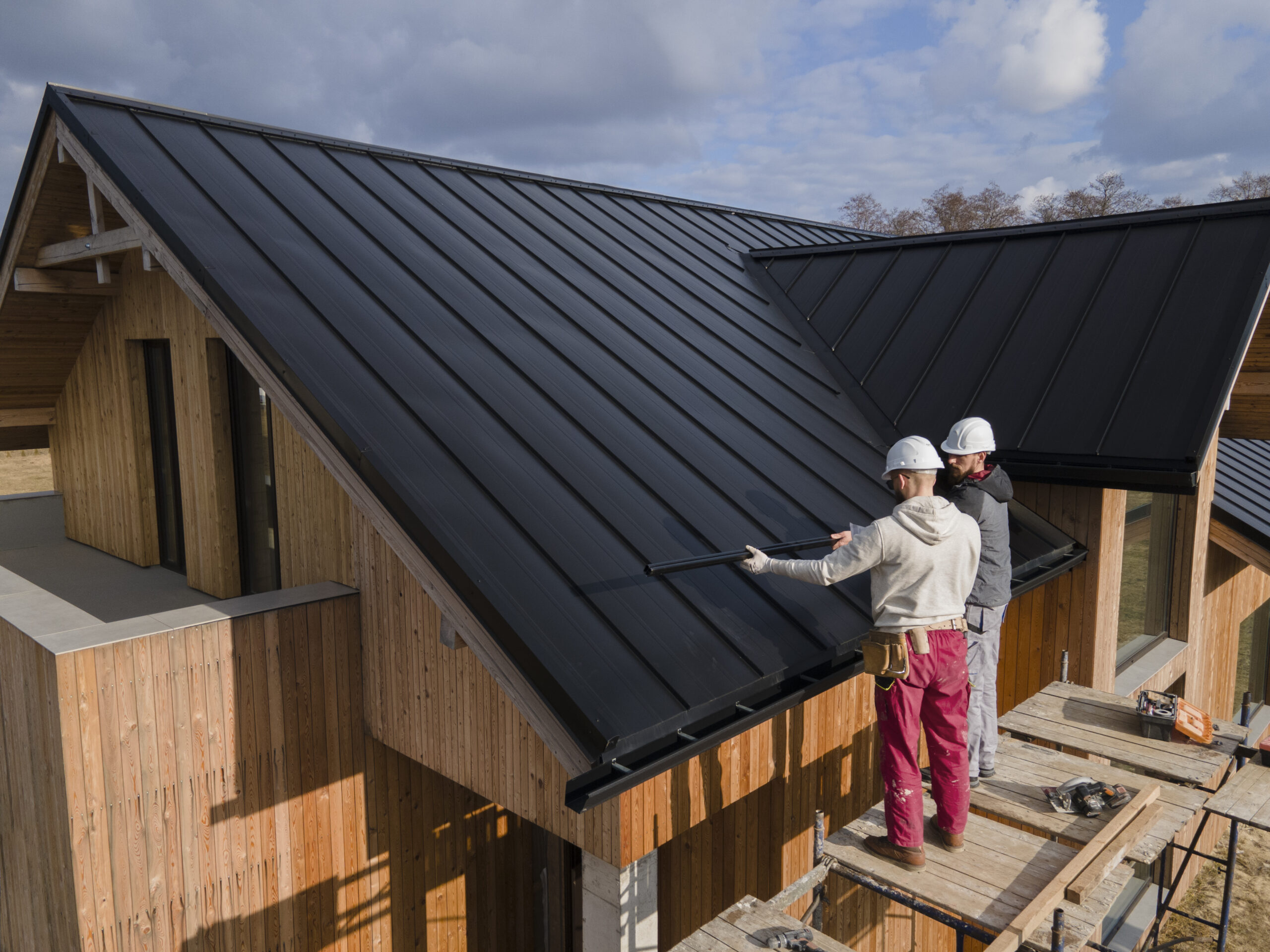 full shot roofers working together with helmets scaled